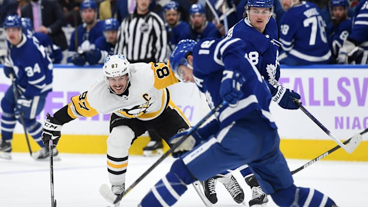 Nov 20, 2021; Toronto, Ontario, CAN;   Pittsburgh Penguins forward Sidney Crosby (87) pursues a loose puck with Toronto Maple Leafs forward Mitch Marner (16) in the third period at Scotiabank Arena. Mandatory Credit: Dan Hamilton-Imagn Images