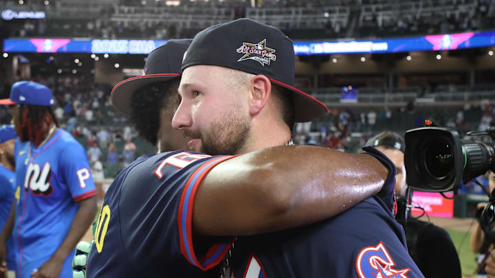 Seattle Mariners catcher Cal Raleigh (29) gets a hug from Tampa Bay Rays infielder Junior Caminero (13) after Raleigh wins the 2025 Home Run Derby at Truist Park on July 14. 