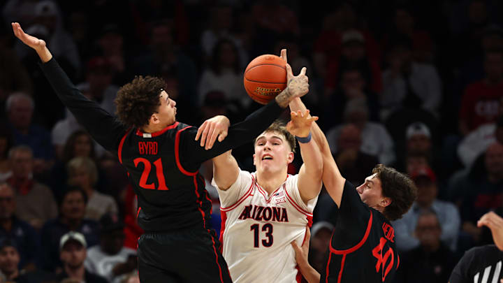 Dec 20, 2025; Phoenix, Arizona, USA; Arizona Wildcats center Motiejus Krivas (13) passes the ball against San Diego State Aztecs guard Miles Byrd (21) and forward Miles Heide (40) in the first half during the Hall of Fame Series at Mortgage Matchup Center. Mandatory Credit: Mark J. Rebilas-Imagn Images