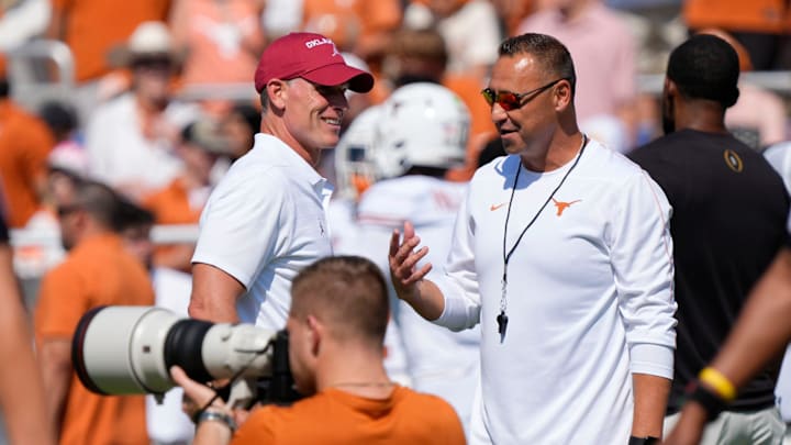 Oklahoma coach Brent Venables talks with Texas coach Steve Sarkisian before the Red River Rivalry college football game between the Oklahoma Sooners and the Texas Longhorns.