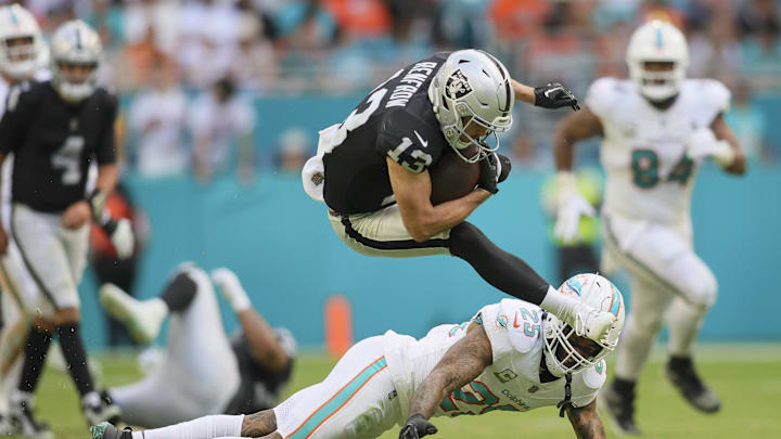 Nov 19, 2023; Miami Gardens, Florida, USA; Las Vegas Raiders wide receiver Hunter Renfrow (13) leaps over Miami Dolphins cornerback Xavien Howard (25) during the fourth quarter at Hard Rock Stadium. Mandatory Credit: Sam Navarro-Imagn Images