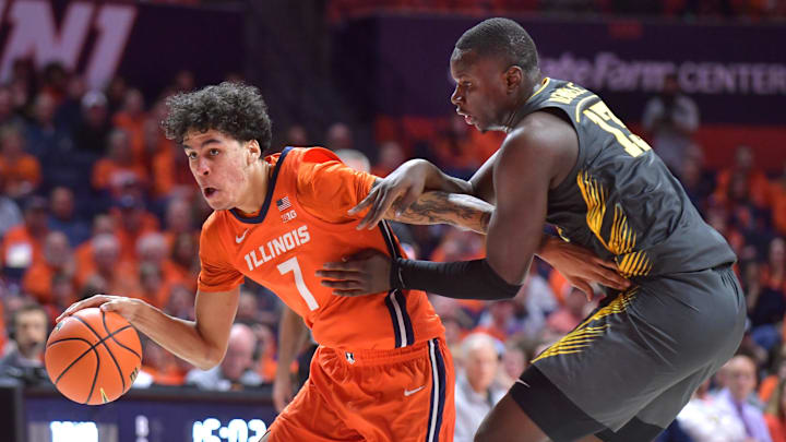 Feb 25, 2025; Champaign, Illinois, USA;  Illinois Fighting Illini forward Will Riley (7) drives the ball past Iowa Hawkeyes forward Ladji Dembele (13) during the
first half at State Farm Center. Mandatory Credit: Ron Johnson-Imagn Images