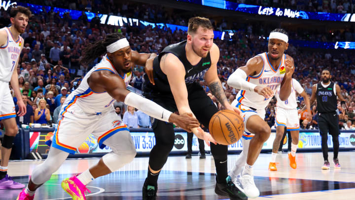May 18, 2024; Dallas, Texas, USA;  Dallas Mavericks guard Luka Doncic (77) passes the ball as Oklahoma City Thunder guard Luguentz Dort (5) and Oklahoma City Thunder guard Shai Gilgeous-Alexander (2) during the second half in game six of the second round of the 2024 NBA playoffs at American Airlines Center. Mandatory Credit: Kevin Jairaj-USA TODAY Sports