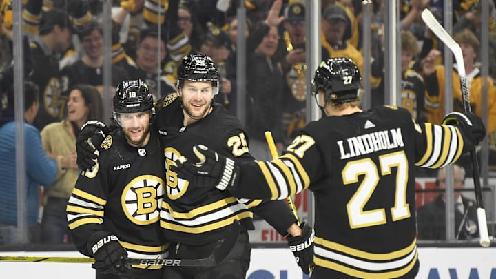 May 12, 2024; Boston, Massachusetts, USA; Boston Bruins center Pavel Zacha (18) and defenseman Hampus Lindholm (27) react with defenseman Brandon Carlo (25) after Carlos goal during the first period in game four of the second round of the 2024 Stanley Cup Playoffs against the Florida Panthers at TD Garden. Mandatory Credit: Bob DeChiara-Imagn Images