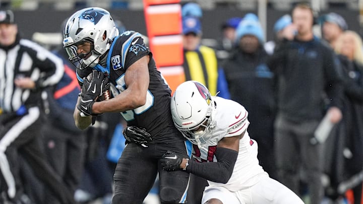 Carolina Panthers running back Chuba Hubbard tries to evade Arizona Cardinals safety Jalen Thompson.