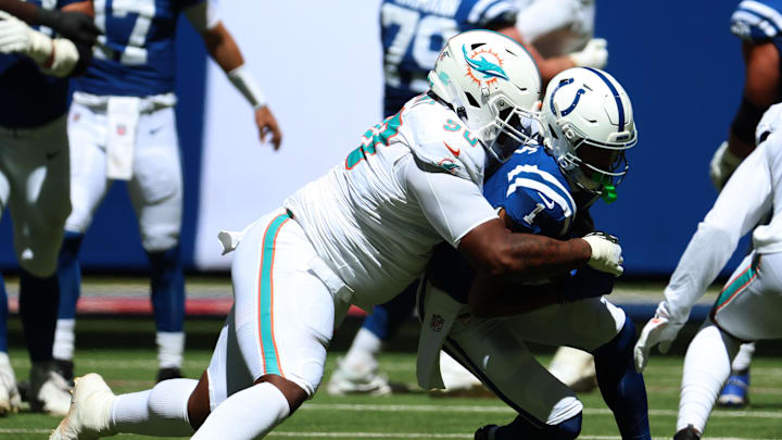 Miami Dolphins defensive tackle Kenneth Grant (90) tackles Indianapolis Colts wide receiver Josh Downs (1) during the first quarter at Lucas Oil Stadium. 