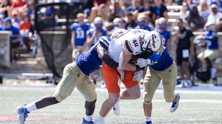 Sep 14, 2024; Tulsa, Oklahoma, USA;  Tulsa Golden Hurricane defenders tackle Oklahoma State Cowboys tight end Josh Ford (40) during the fourth quarter at Skelly Field at H.A. Chapman Stadium. Mandatory Credit: Brett Rojo-Imagn Images