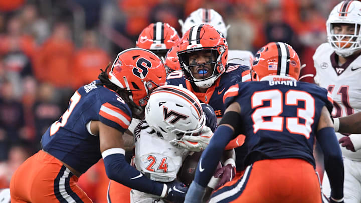 Nov 2, 2024; Syracuse, New York, USA; Virginia Tech Hokies running back Malachi Thomas (24) is tackled by Syracuse Orange defensive lineman Fadil Diggs (10) and defensive lineman Isaiah Hastings (9) in the fourth quarter at JMA Wireless Dome. Mandatory Credit: Mark Konezny-Imagn Images