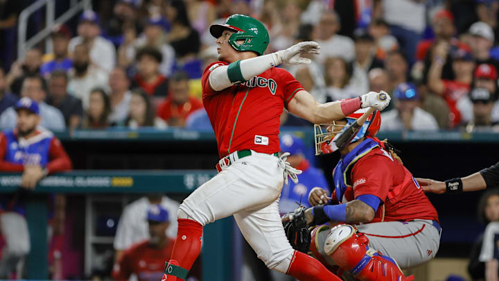 Mar 17, 2023; Miami, Florida, USA; Mexico second baseman Luis Urias (3) hits an RBI single during the seventh inning against Puerto Rico at LoanDepot Park. Mandatory Credit: Sam Navarro-Imagn Images