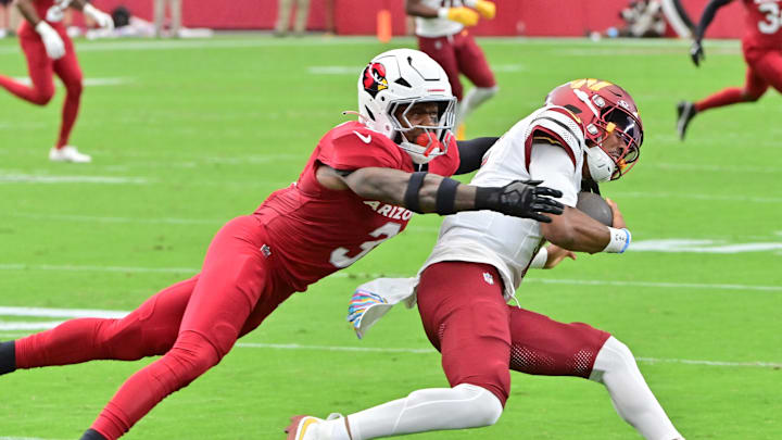 Sep 29, 2024; Glendale, Arizona, USA;  Arizona Cardinals safety Budda Baker (3) tackles Washington Commanders quarterback Jayden Daniels (5) in the first half at State Farm Stadium. 