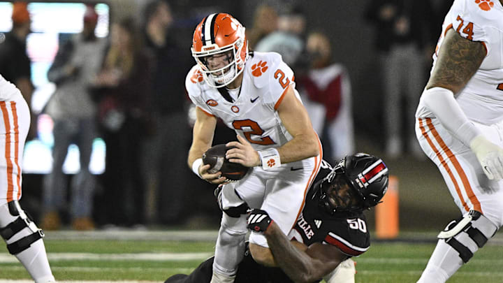 Nov 14, 2025; Louisville, Kentucky, USA; Louisville Cardinals defensive lineman Clev Lubin (50) sacks Clemson Tigers quarterback Cade Klubnik (2) during the first half at L&N Federal Credit Union Stadium. Mandatory Credit: Jamie Rhodes-Imagn Images Nov 14, 2025; Louisville, Kentucky, USA; Louisville Cardinals defensive lineman Clev Lubin (50) sacks Clemson Tigers quarterback Cade Klubnik (2) during the first half at L&N Federal Credit Union Stadium. Mandatory Credit: Jamie Rhodes-Imagn Images