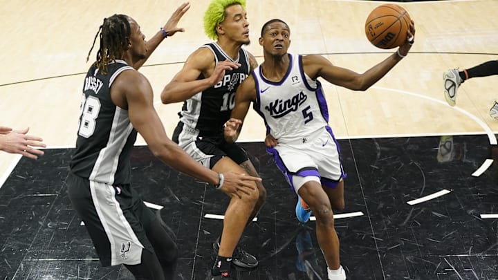Dec 6, 2024; San Antonio, Texas, USA; Sacramento Kings guard De'Aaron Fox (5) drives to the basket against San Antonio Spurs center Charles Bassey (28) and forward Jeremy Sochan (10) during the first half at Frost Bank Center. Mandatory Credit: Scott Wachter-Imagn Images Dec 6, 2024; San Antonio, Texas, USA; Sacramento Kings guard De'Aaron Fox (5) drives to the basket against San Antonio Spurs center Charles Bassey (28) and forward Jeremy Sochan (10) during the first half at Frost Bank Center. Mandatory Credit: Scott Wachter-Imagn Images