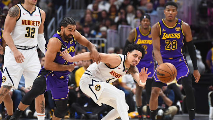 Feb 22, 2025; Denver, Colorado, USA; Los Angeles Lakers guard Gabe Vincent (7) knocks the ball away from Denver Nuggets guard Julian Strawther (3) during the second half at Ball Arena. Mandatory Credit: Christopher Hanewinckel-Imagn Images