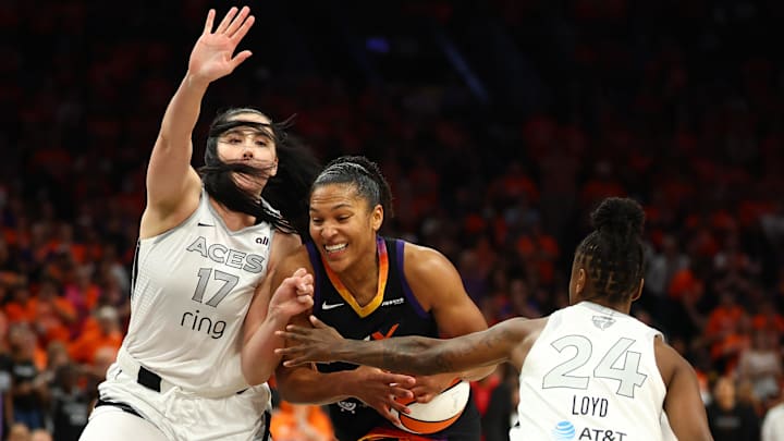 Oct 8, 2025; Phoenix, Arizona, USA;Phoenix Mercury forward Alyssa Thomas (25) dribbles past Las Vegas Aces center Megan Gustafson (17) and guard Jewell Loyd (24) in the second half during game three of the 2025 WNBA Finals at PHX Arena. Mandatory Credit: Mark J. Rebilas-Imagn Images