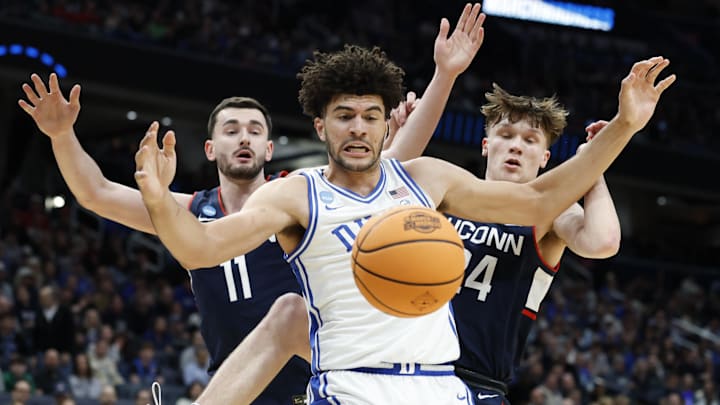 Mar 29, 2026; Washington, DC, USA; Duke Blue Devils forward Cameron Boozer (12) and UConn Huskies forward Alex Karaban (11) go for a loose ball in the first half during an Elite Eight game of the East Regional of the men's 2026 NCAA Tournament at Capital One Arena. Mar 29, 2026; Washington, DC, USA; Duke Blue Devils forward Cameron Boozer (12) and UConn Huskies forward Alex Karaban (11) go for a loose ball in the first half during an Elite Eight game of the East Regional of the men's 2026 NCAA Tournament at Capital One Arena.