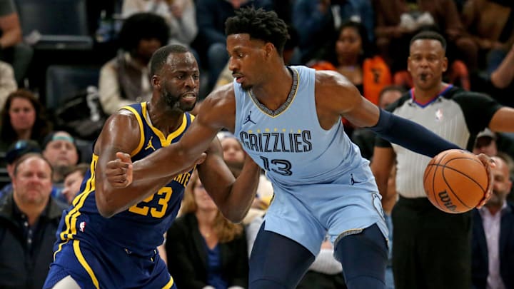 Feb 2, 2024; Memphis, Tennessee, USA; Memphis Grizzlies forward-center Jaren Jackson Jr. (13) dribbles as Golden State Warriors forward Draymond Green (23) defends during the second half at FedExForum. Mandatory Credit: Petre Thomas-Imagn Images