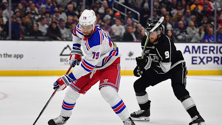 Jan 20, 2024; Los Angeles, California, USA; New York Rangers defenseman K'Andre Miller (79) moves the puck ahead of Los Angeles Kings right wing Adrian Kempe (9) durng the second period at Crypto.com Arena. Mandatory Credit: Gary A. Vasquez-Imagn Images