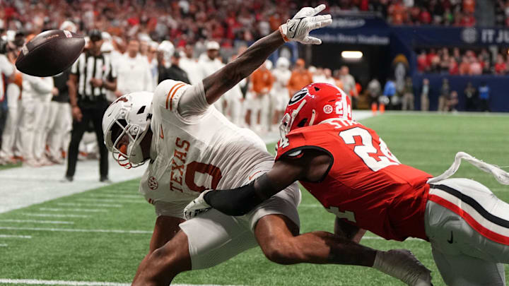 Dec 7, 2024; Atlanta, GA, USA; Texas Longhorns wide receiver DeAndre Moore Jr. (0) attempts to make a catch over Georgia Bulldogs defensive back Malaki Starks (24) during the second half in the 2024 SEC Championship game at Mercedes-Benz Stadium. Mandatory Credit: Dale Zanine-Imagn Images