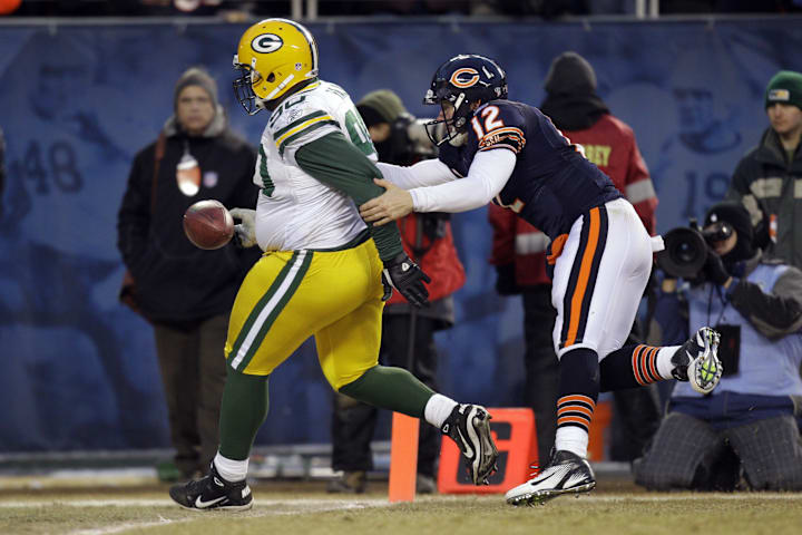 Green Bay Packers defensive tackle B.J. Raji (90) returns an interception for a touchdown past Bears quarterback Caleb Hanie.