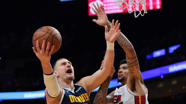 Dec 29, 2025; Miami, Florida, USA; Denver Nuggets center Nikola Jokic (15) drives to the basket against Miami Heat center Kel'El Ware (7) during the first quarter at Kaseya Center. Mandatory Credit: Sam Navarro-Imagn Images