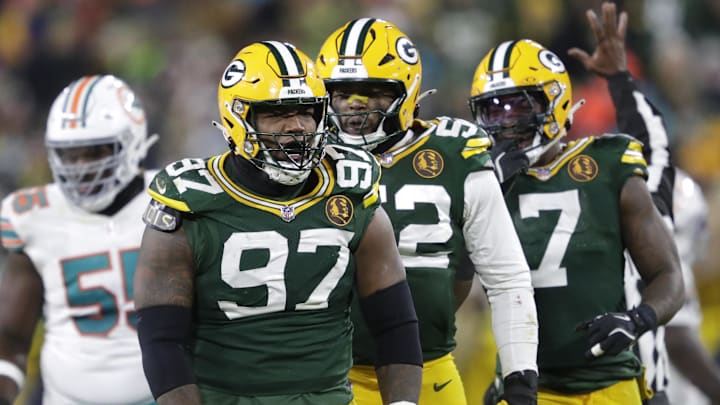 Nov 28, 2024; Green Bay, Wisconsin, USA; Green Bay Packers defensive tackle Kenny Clark (97) celebrates sacking Miami Dolphins quarterback Tua Tagovailoa with defensive end Rashan Gary (52) and linebacker Quay Walker (7) at Lambeau Field. Mandatory Credit: Dan Powers-Imagn Images