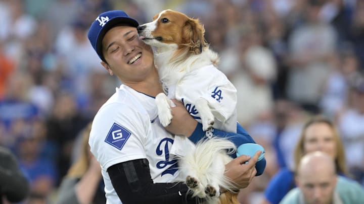 Aug 28, 2024; Los Angeles, California, USA;  Los Angeles Dodgers designated hitter Shohei Ohtani (17) with his dog Decoy after he delivered he first pitch before the game against the Baltimore Orioles at Dodger Stadium. Mandatory Credit: Jayne Kamin-Oncea-Imagn Images