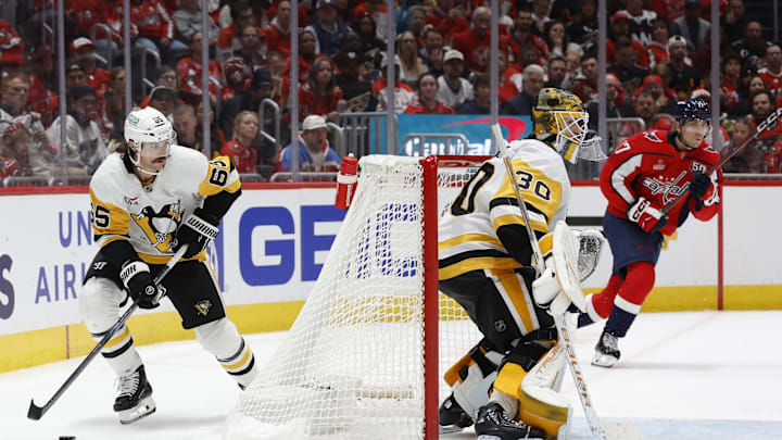 Nov 8, 2024; Washington, District of Columbia, USA; Pittsburgh Penguins defenseman Erik Karlsson (65) skates with the puck behind Penguins goaltender Joel Blomqvist (30) as Washington Capitals center Dylan Strome (17) chases in the third period at Capital One Arena. Mandatory Credit: Geoff Burke-Imagn Images