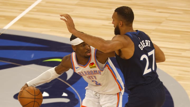 May 24, 2025; Minneapolis, Minnesota, USA; Oklahoma City Thunder guard Shai Gilgeous-Alexander (2) dribbles the ball against Minnesota Timberwolves center Rudy Gobert (27) during the first half in game three of the western conference finals for the 2025 NBA Playoffs at Target Center. Mandatory Credit: Bruce Kluckhohn-Imagn Images