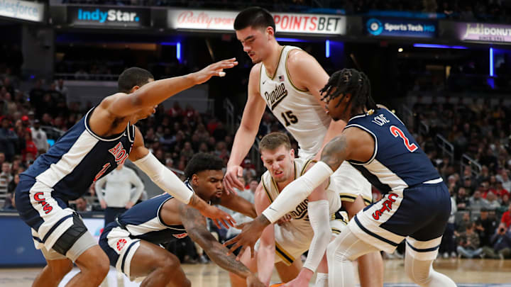 Purdue Boilermakers and Arizona Wildcats players fight for a loose ball during the NCAA men's basketball game, Saturday, Dec. 16, 2023, at Gainbridge Fieldhouse in Indianapolis. Purdue Boilermakers won 92-84.