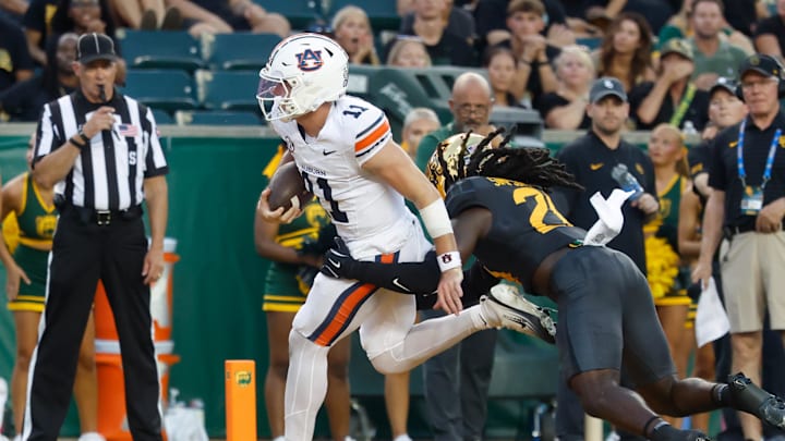 Aug 29, 2025; Waco, Texas, USA;  Auburn Tigers quarterback Jackson Arnold (11) runs the ball for a touchdown against Baylor Bears cornerback Calvin Simpson-Hunt (28) during the first half at McLane Stadium. Mandatory Credit: Chris Jones-Imagn Images
