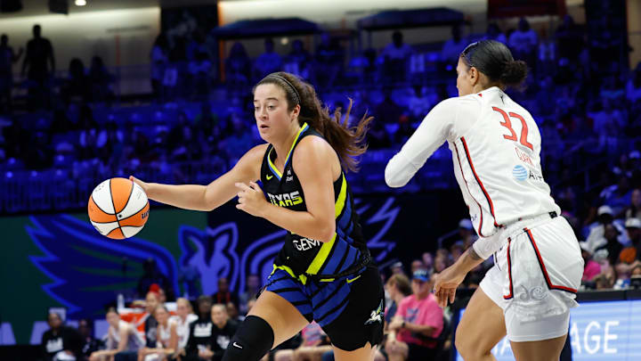 Dallas Wings forward Maddy Siegrist controls the ball as Washington Mystics forward Alysha Clark defends.