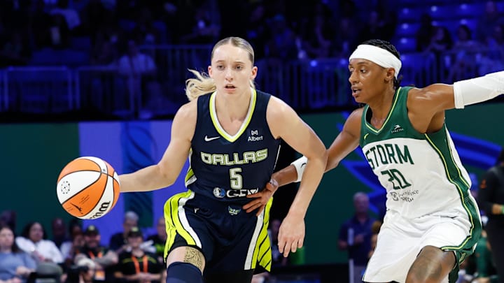 Dallas Wings guard Paige Bueckers controls the ball as Seattle Storm guard Brittney Sykes defends.