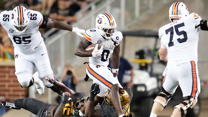 Aug 29, 2025; Waco, Texas, USA;  Auburn Tigers running back Damari Alston (0) runs the ball against Baylor Bears defensive lineman Devonte Tezino (59) during the first half at McLane Stadium. Mandatory Credit: Chris Jones-Imagn Images