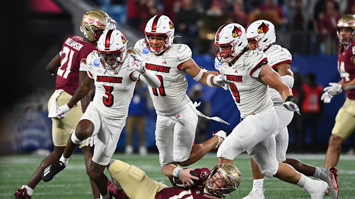 Dec 2, 2023; Charlotte, NC, USA; Florida State Seminoles quarterback Brock Glenn (11) slides to avoid the tackle by Louisville Cardinals defensive backs Quincy Riley (3) and Cam'Ron Kelly (11), and defensive lineman Ashton Gillotte (9) in the third quarter at Bank of America Stadium. Mandatory Credit: Bob Donnan-USA TODAY Sports