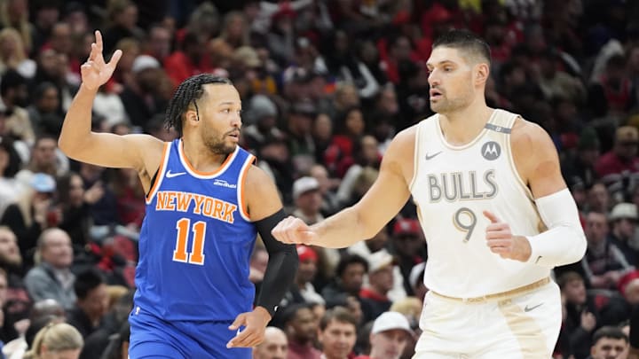 Jan 4, 2025; Chicago, Illinois, USA; New York Knicks guard Jalen Brunson (11) gestures after making a three point basket as Chicago Bulls center Nikola Vucevic (9) looks on during the first quarter at United Center. Mandatory Credit: David Banks-Imagn Images