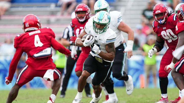 Nov 18, 2023; Boca Raton, Florida, USA; Tulane Green Wave running back Makhi Hughes (21) runs the ball against the Florida Atlantic Owls in the second half at FAU Stadium. Mandatory Credit: Jim Rassol-Imagn Images