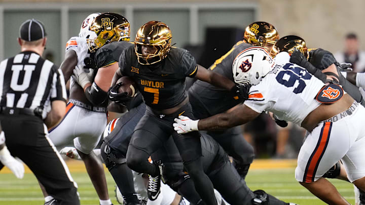 Aug 29, 2025; Waco, Texas, USA; Baylor Bears running back Bryson Washington (7) runs the ball as Auburn Tigers defensive lineman Malik Autry (96) defends during the first half at McLane Stadium. Mandatory Credit: Chris Jones-Imagn Images