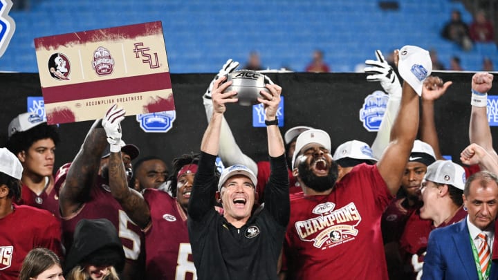 Dec 2, 2023; Charlotte, NC, USA; Florida State Seminoles head coach Mike Norvell raises the ACC Championship trophy with his players after the game against the Louisville Cardinals at Bank of America Stadium. Mandatory Credit: Bob Donnan-USA TODAY Sports Dec 2, 2023; Charlotte, NC, USA; Florida State Seminoles head coach Mike Norvell raises the ACC Championship trophy with his players after the game against the Louisville Cardinals at Bank of America Stadium. Mandatory Credit: Bob Donnan-USA TODAY Sports