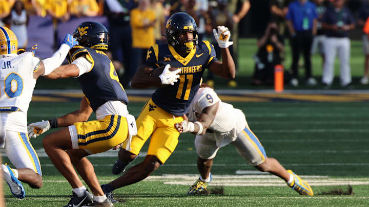 West Virginia University receiver Justin Smith-Brown breaks the tackle of Pitt linebacker Kyle Louis West Virginia University receiver Justin Smith-Brown breaks the tackle of Pitt linebacker Kyle Louis