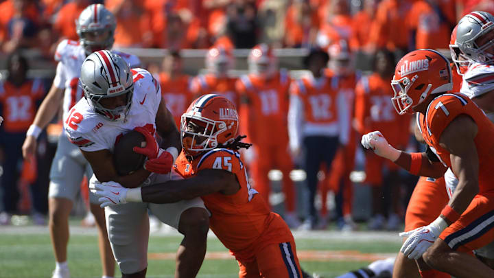Oct 11, 2025; Champaign, Illinois, USA; Ohio State Buckeyes running back CJ Donaldson Jr. (12) is tackled by Illinois Fighting Illini linebacker Malachi Hood (45) during the first quarter at Memorial Stadium. Mandatory Credit: Ron Johnson-Imagn Images