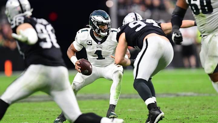 Oct 24, 2021; Paradise, Nevada, USA; Philadelphia Eagles quarterback Jalen Hurts (1) moves the ball under pressure from Las Vegas Raiders defensive end Carl Nassib (94) and defensive tackle Darius Philon (96) during the second half at Allegiant Stadium. Mandatory Credit: Gary A. Vasquez-Imagn Images