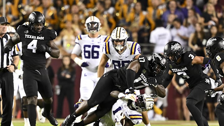 Oct 26, 2024; College Station, Texas, USA; Texas A&M Aggies defensive back Marcus Ratcliffe (3) and defensive lineman Albert Regis (17) tackle LSU Tigers wide receiver Aaron Anderson (1) during the third quarter. The Aggies defeated the Tigers 38-23; at Kyle Field. Mandatory Credit: Maria Lysaker-Imagn Images. Oct 26, 2024; College Station, Texas, USA; Texas A&M Aggies defensive back Marcus Ratcliffe (3) and defensive lineman Albert Regis (17) tackle LSU Tigers wide receiver Aaron Anderson (1) during the third quarter. The Aggies defeated the Tigers 38-23; at Kyle Field. Mandatory Credit: Maria Lysaker-Imagn Images.
