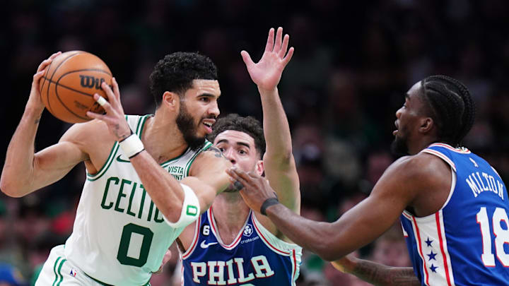 Feb 8, 2023; Boston, Massachusetts, USA; Boston Celtics forward Jayson Tatum (0) moves the ball against Philadelphia 76ers guard Shake Milton (18) and forward Georges Niang (20) in the second half at TD Garden. Mandatory Credit: David Butler II-Imagn Images