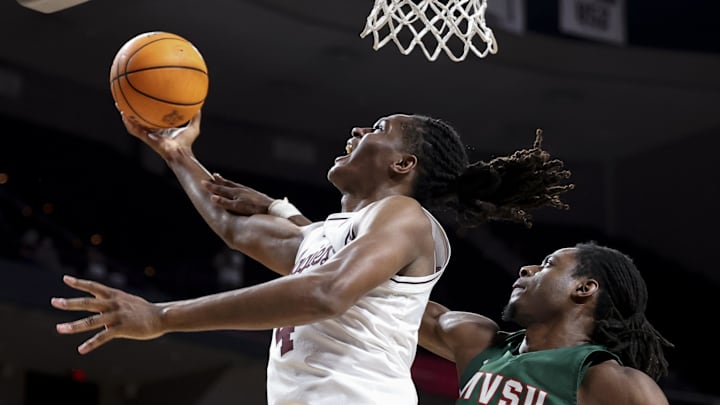 Nov 25, 2025; College Station, Texas, USA; Texas A&M Aggies forward Jamie Vinson (4) is folded by Mississippi Valley State Delta Devils forward Tyrone Iroghama (13) during the first half at Reed Arena. Mandatory Credit: Maria Lysaker-Imagn Images 