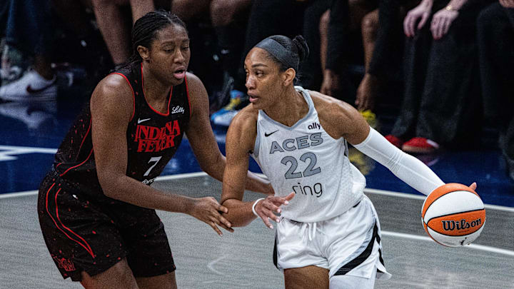 Sep 28, 2025; Indianapolis, Indiana, USA; Las Vegas Aces center A'ja Wilson (22) dribbles the ball while Indiana Fever forward Aliyah Boston (7) defends in the first half  during game four of the second round for the 2025 WNBA Playoffs at Gainbridge Fieldhouse. Mandatory Credit: Trevor Ruszkowski-Imagn Images