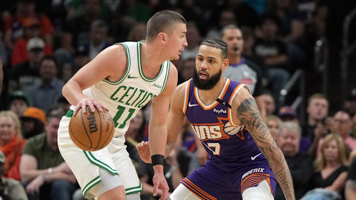 Mar 26, 2025; Phoenix, Arizona, USA; Boston Celtics guard Payton Pritchard (11) drives on Phoenix Suns forward Cody Martin (17) during the first half at Footprint Center. Mandatory Credit: Rick Scuteri-Imagn Images