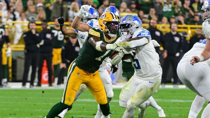 Detroit Lions running back David Montgomery (5) tries to break a tackle by Green Bay Packers linebacker Quay Walker (7).