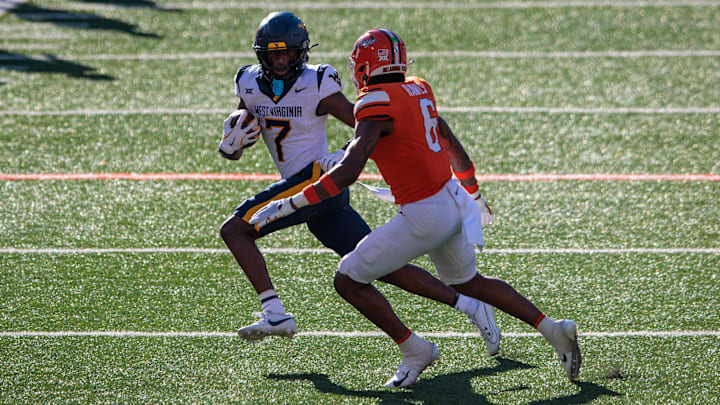 Oct 5, 2024; Stillwater, Oklahoma, USA; West Virginia Mountaineers wide receiver Traylon Ray (7) runs the ball against Oklahoma State Cowboys safety Lyrik Rawls (6) during the third quarter at Boone Pickens Stadium. Mandatory Credit: William Purnell-Imagn Images