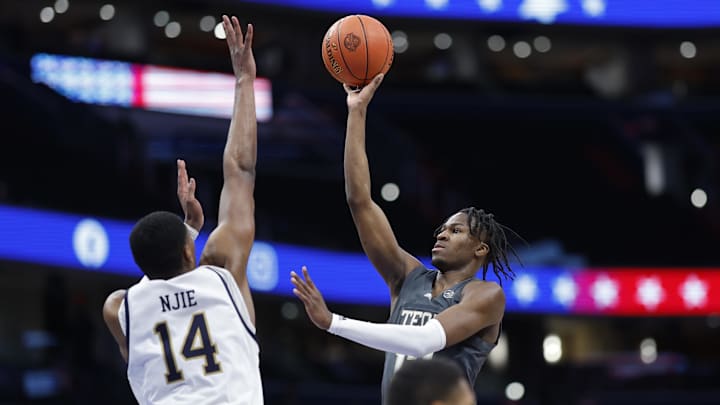 Mar 12, 2024; Washington, D.C., USA; Georgia Tech Yellow Jackets guard Miles Kelly (13) shoots the ball as Notre Dame Fighting Irish forward Kebba Njie (14) defends in the first half at Capital One Arena. Mandatory Credit: Geoff Burke-Imagn Images