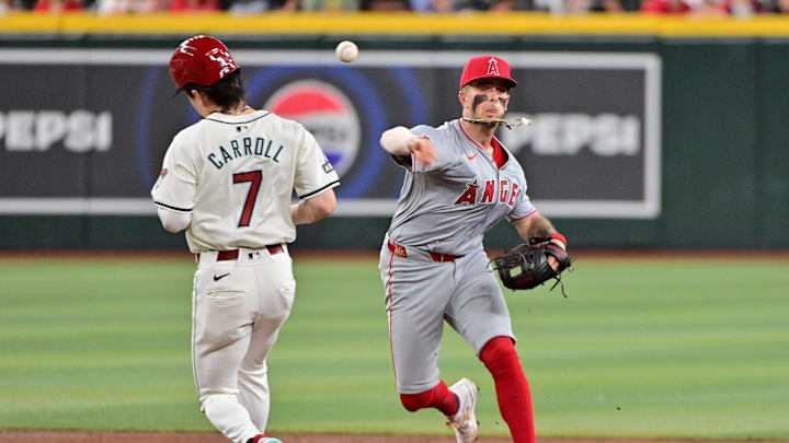 Jun 12, 2024; Phoenix, Arizona, USA; Los Angeles Angels shortstop Zach Neto (9) turns a double play on Arizona Diamondbacks outfielder Corbin Carroll (7) in the first inning at Chase Field. Mandatory Credit: Matt Kartozian-USA TODAY Sports